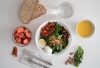Top view of a nutritious breakfast with salad, eggs, bread, and juice, perfect for a healthy start.